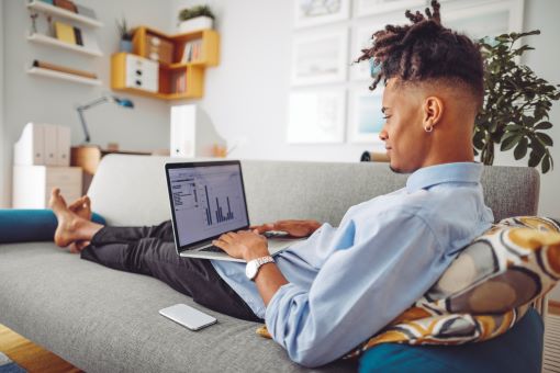 Homme consultant des tableaux d’actions pour investir en bourse.