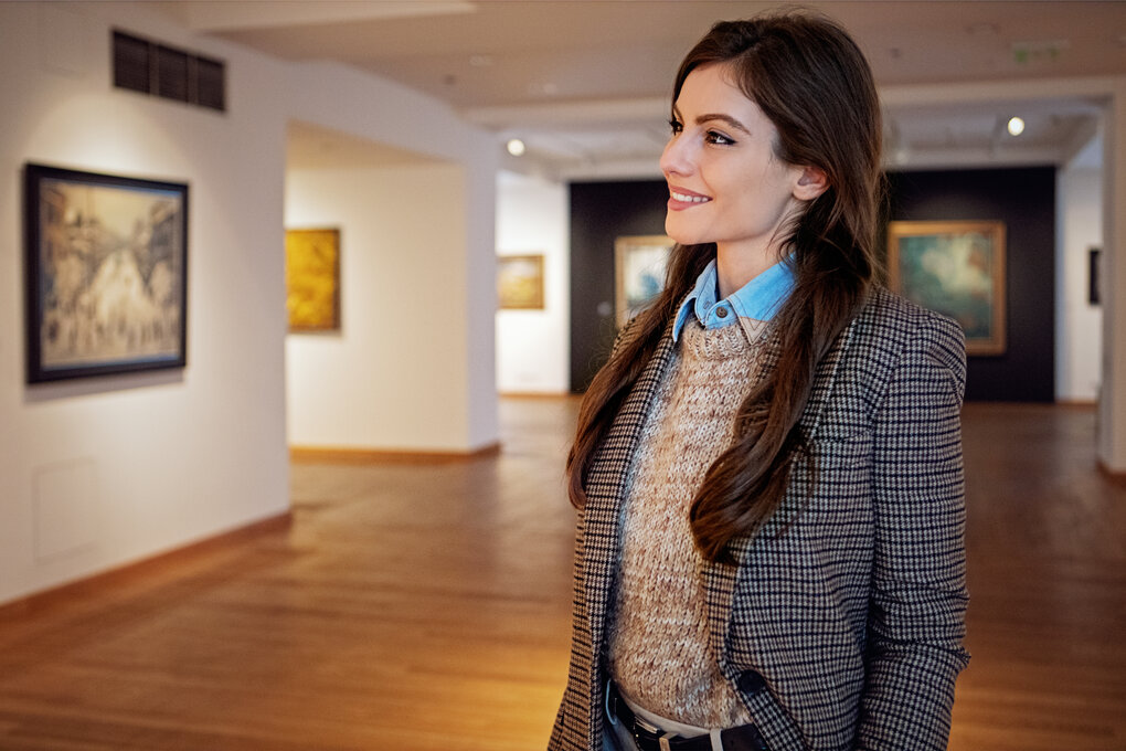 Une femme regardant une œuvre d’art dans une galerie d'art
